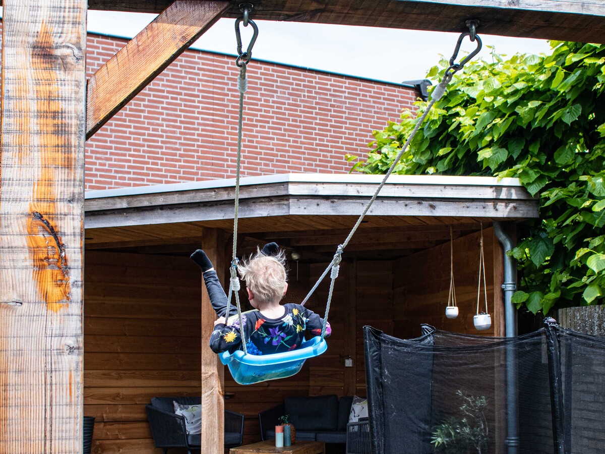 Schommel, overkapping, fietsenhok en poort voor een extra ingang in de tuin. 