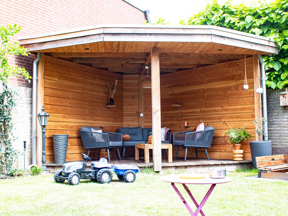 Schommel, overkapping, fietsenhok en poort voor een extra ingang in de tuin. 